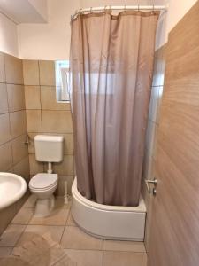 a bathroom with a toilet and a shower curtain at Apartments Kegalj in Podstrana