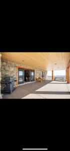 a large room with a stone wall and a fireplace at Heart West Haven in Priddis