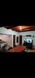 uma sala de estar com uma mesa e uma televisão de ecrã plano em CASA BARBARA em Santa Elena