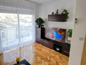 sala de estar con TV de pantalla plana grande en Apartments Kegalj, en Podstrana