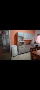 uma cozinha com um frigorífico e uma mesa em CASA BARBARA em Santa Elena
