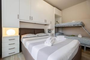 een slaapkamer met 2 bedden en een stapelbed bij La Casa Nuova - Pietra Ligure in Pietra Ligure