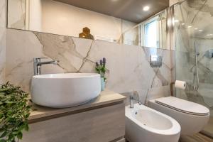 een witte badkamer met een wastafel en een toilet bij La Casa Nuova - Pietra Ligure in Pietra Ligure +20 foto's