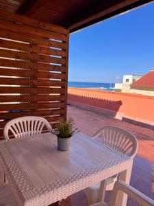 una mesa y sillas en un patio con vistas al océano en Casa Vacanze Filippa, en Balestrate