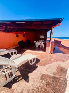 eine Terrasse mit weißen Stühlen und einem Tisch auf dem Dach in der Unterkunft Casa Vacanze Filippa in Balestrate