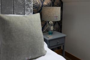 a lamp on a night stand next to a bed at Stornoway Bed and Breakfast in Stornoway