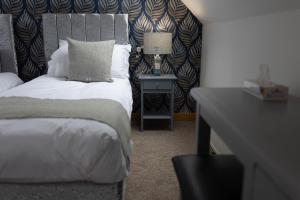een slaapkamer met een bed en een tafel met een lamp bij Stornoway Bed and Breakfast in Stornoway