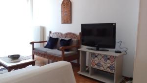 a living room with a tv and a couch at Nostos-Δωρεάν κλειστός χώρος στάθμευσης in Volos