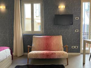 - une chambre avec une chaise et une télévision murale dans l'établissement Loft 17 Arena, à Vérone
