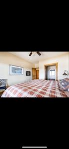 a bedroom with a large bed with a plaid blanket at Heart West Haven in Priddis