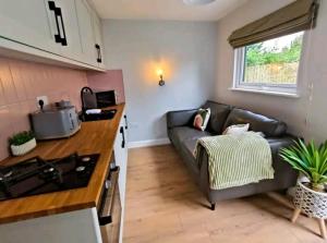 a living room with a couch and a kitchen at The Annex, Stratford Upon-Avon in Stratford-upon-Avon