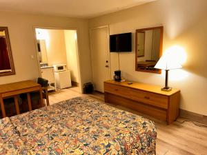 um quarto de hotel com uma cama, uma secretária e um espelho em River forest inn em Belton