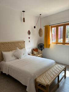 Un dormitorio con una gran cama blanca y una ventana en Santa Cecilia Hotel en Oaxaca de Juárez