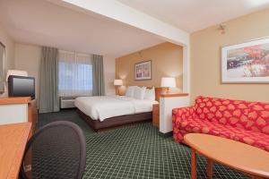 a hotel room with a bed and a couch at Wingate by Wyndham Sioux City in Sioux City
