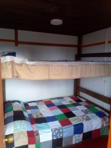 a bunk bed with a colorful quilt on it at Casa La Aurora "Posada" in Restrepo