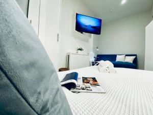 a bedroom with a bed with a tv on the wall at Apt 08 Beachside Beauty Central Studio Steps from Cafes in Brighton & Hove