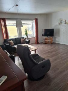 ein Wohnzimmer mit einem Sofa und einem TV in der Unterkunft Fjellveien 4 in Vadsø