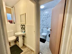 a bathroom with a toilet and a sink at Whitechapel Station Rooms R1 in London