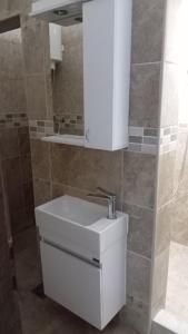 a bathroom with a white sink and a mirror at Smestaj SIMOVIC 1 in Arilje +4 photos