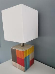 a colorful lamp on top of a wooden block at Fewo Küste und Wald in Gelbensande