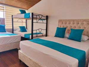 a bedroom with two bunk beds with blue pillows at Hotel Batan 127 in Bogotá
