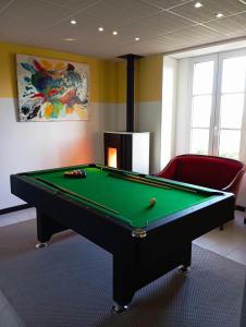 Zimmer mit einem Billardtisch und einem roten Stuhl in der Unterkunft Chambres au Manoir 3 au 8 juin ! in Subles
