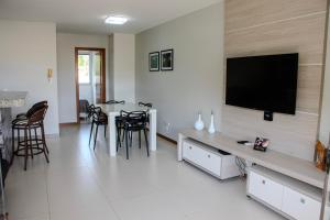 Una sala de estar con un televisor de pantalla plana en una pared. en Solaris Imbassai TOP Flat, en Imbassai