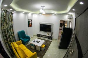a living room with a yellow couch and a tv at Ryan Apartments in Hurghada