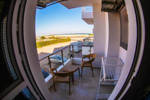 a balcony with chairs and a table and a view of the beach at Ryan Apartments in Hurghada