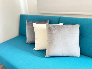 eine blaue Couch mit drei Kissen drauf in der Unterkunft Apt 09 Stylish Studio Steps from Sea & Promenade in Brighton & Hove