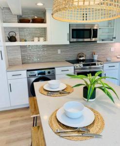 a kitchen with a table with bowls and plates on it at Cozy, Renovated 1Bed Suite, Full Kitchen, 5 min to Westport in Weston
