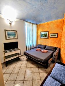 a bedroom with a bed and a desk with a television at -La Terrazza nel Vigneto- [Golfo dei Poeti] in Tellaro