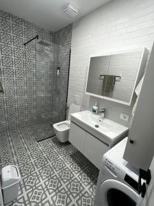 a bathroom with a sink and a shower and a toilet at Green Apartment Durrës in Durrës
