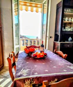 uma mesa com uma taça de fruta e uma garrafa de vinho em -La Terrazza nel Vigneto- [Golfo dei Poeti] em Tellaro