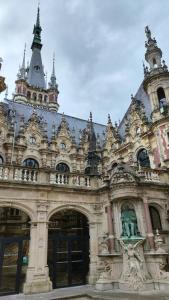 a large building with a statue in front of it at L Alchimie in Fécamp