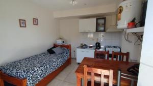a small room with a bed and a kitchen with a table at Altos Mendoza Calle Entre Ríos in Mendoza