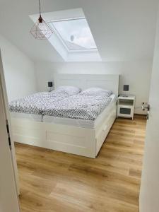 a white bedroom with a bed with a skylight at Bei Freddy in Prüm