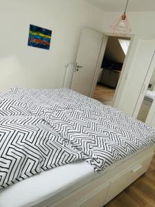 a white bed with a black and white comforter at Bei Freddy in Prüm