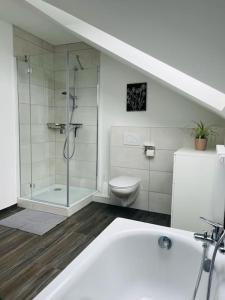 a bathroom with a shower and a tub and a toilet at Bei Freddy in Prüm