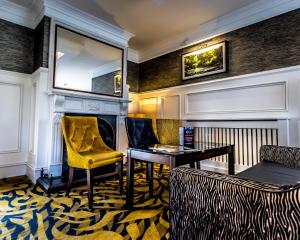 a living room with a yellow chair and a desk at Ballymac Hotel in Stonyford