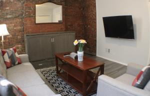 2 Bedroom East Carson Street Sanctuary في بيتسبرغ: غرفة معيشة مع طاولة عليها زهور
