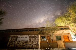 un edificio con un cartel bajo un cielo estrellado en Tantakuy Eco Experience Hotel en La Huaica