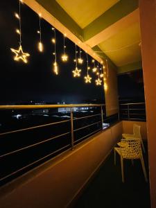 a balcony with lights and a table and a chair at Ujoni Homestay in Duliajan in Duliāgaon
