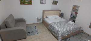 a small bedroom with a bed and a chair at New Studio in Pogradec