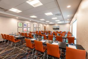 a conference room with tables and orange chairs at Holiday Inn Express & Suites - Rock Hill, an IHG Hotel in Rock Hill
