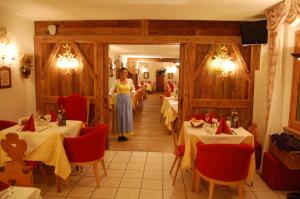 una donna in piedi in una sala da pranzo con tavoli di Chalet Fiocco Di Neve a Pinzolo Altre 107 foto