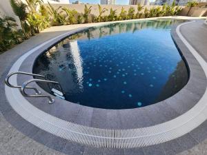 a swimming pool with a curved coping around it at la fontaine in Nabeul