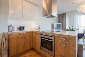a kitchen with wooden cabinets and a stove top oven at City Center Luxury Apartment in Tartu