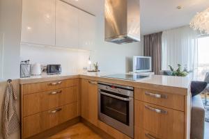 Una cocina con gabinetes de madera y un horno de estufa. en City Center Luxury Apartment, en Tartu