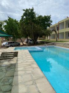 duży niebieski basen obok budynku w obiekcie Lagos Diani w mieście Diani Beach
